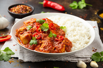 Spicy Chicken Pathia curry with basmati rice in a white plate. healthy food.