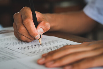 Students writing and reading exam answer sheets exercises in classroom