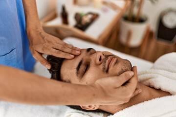 Obraz na płótnie Canvas Man smiling happy reciving head massage at beauty center.