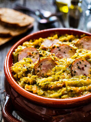 Cooked young cabbage with sausage on wooden table 
