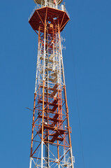 Top part of the TV tower against the background of the summer blue sky. City of Blagoveshchensk, Russia.