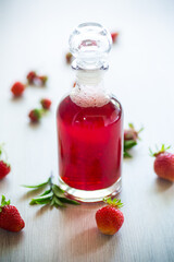 sweet cooked strawberry syrup in a glass decanter