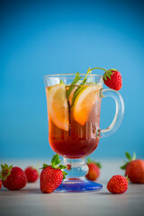 refreshing cool strawberry lemonade with lemon, ice and mint in a glass