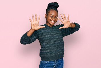 Young african american woman wearing casual clothes showing and pointing up with fingers number ten while smiling confident and happy.