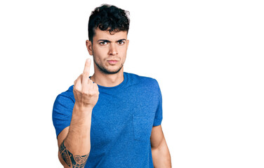 Young hispanic man wearing casual t shirt showing middle finger, impolite and rude fuck off...