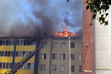 Blurred photo of a high-rise building on fire in summer on a hot sunny day