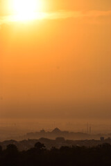 Naklejka premium The sun rises over the city of Semarang covered by clouds