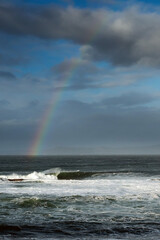 Colorful rainbow over Atlantic ocean, Mullaghmore, county Sligo, Ireland. Blue cloudy sky. Vertical image
