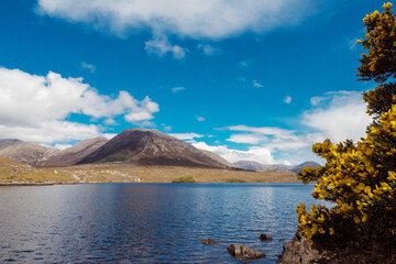 Lake Derryclare Lough in Connemara, county Galway, Ireland. Irish nature landscape. Beautiful scene with water, mountains and blue cloudy sky. Nobody. Popular tourist landmark