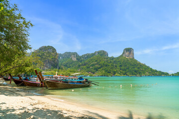 Fototapeta na wymiar Railay beach east with exotic limestone mountain and longtail wooden tourist boat, Krabi, Thailand