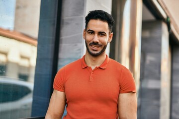 Obraz premium Young hispanic man smiling happy standing at the city.