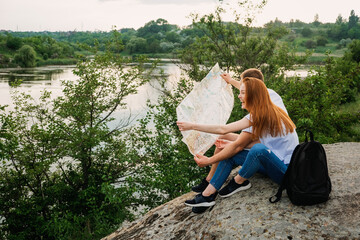 Solo travelers, planning local vacation, vacation in locations visit couple. Couple in love tourist sitting on stone by the river read the map. Romantic getaway, Romantic Destinations to Honeymoon