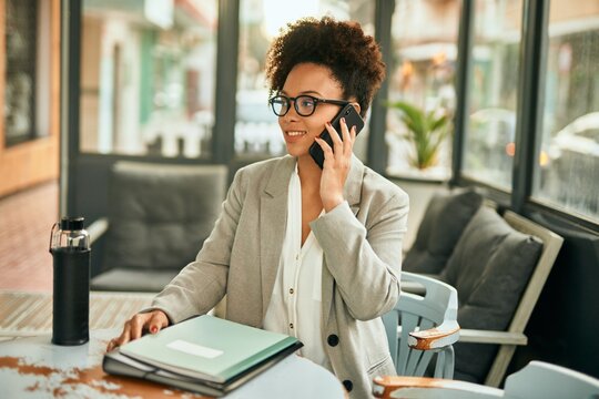 Young african american businesswoman smiling happy talking on the smartphone sitting at coffee shop.