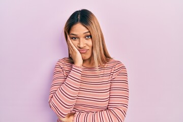 Fototapeta premium Beautiful hispanic woman wearing casual striped sweater thinking looking tired and bored with depression problems with crossed arms.