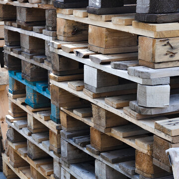 A stack of old wooden pallets for loading. Logistics and cargo delivery. Square background