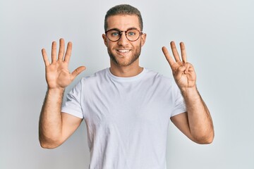 Young caucasian man wearing casual clothes and glasses showing and pointing up with fingers number eight while smiling confident and happy.