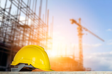 yellow helmet in construction site and construction site background safety first concept