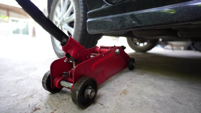 Lift the car with a hydraulic jack to change the wheels. by yourself at home