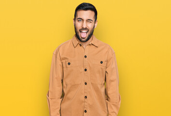 Young hispanic man wearing casual clothes sticking tongue out happy with funny expression. emotion concept.