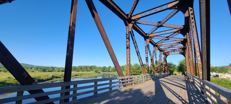 a old railway Trussell with a board walk and a blue sky