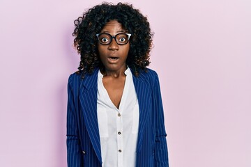 Young african american woman wearing business clothes and glasses afraid and shocked with surprise...