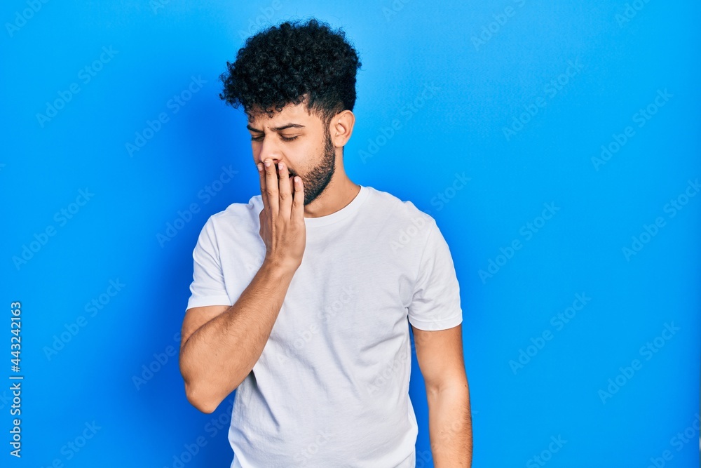 Sticker Young arab man with beard wearing casual white t shirt bored yawning tired covering mouth with hand. restless and sleepiness.