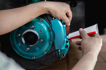 Disk brake service concept : Close up hand a man use Grease Anti-seize to brake pad and cleaning...