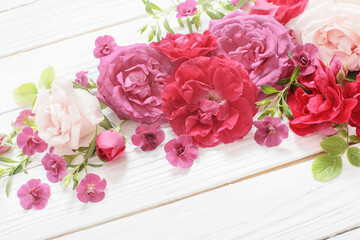 pink and red roses on white wooden background