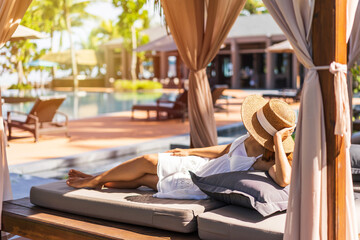 Young woman traveler relaxing and enjoying by a tropical resort pool while traveling for summer...