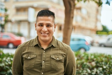 Fototapeta premium Young latin man smiling happy standing at the city.