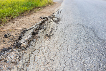 Close-up of the paved surface of a broken road in rural Thailand.