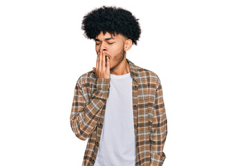Obraz na płótnie Canvas Young african american man with afro hair wearing casual clothes bored yawning tired covering mouth with hand. restless and sleepiness.
