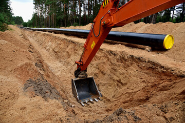 Natural Gas Pipeline Construction. Laying oil pipe in a trench in the ground. Petrochemical...