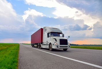 American semi truck transporting sea container on highway on sunset background. Shipping Containers Delivery, Maritime Services and Transport logistics. 