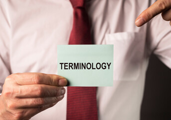 Terminology word on paper note in hands of businessman. Concept of terms in finance, business and...