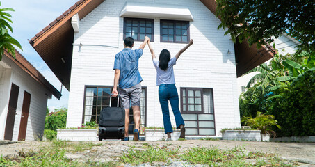 Happy couple in front of the New Home On Moving In Day, and start a new life family. Concept of...