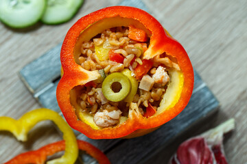 Fried bulgur with poultry meat and stewed vegetables served with red bell pepper. Exotic dish, top view