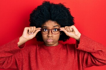 Young african american woman wearing glasses skeptic and nervous, frowning upset because of...