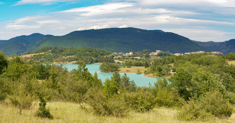 Summer scenery of the lake and the village of castel san vincenzo, immersed in the green of nature, Molise, Italy