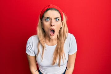 Young caucasian woman wearing casual white t shirt afraid and shocked with surprise and amazed...