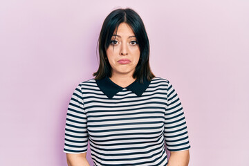 Fototapeta premium Young hispanic woman wearing casual clothes depressed and worry for distress, crying angry and afraid. sad expression.