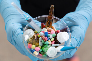 Bowl full of medicine, pills, drops in a hands of medical assistant