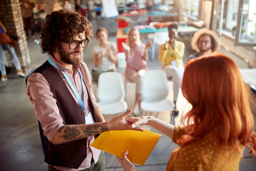 A young male office employee is getting company award