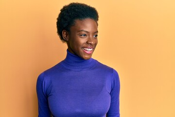 Young african american girl wearing casual clothes looking to side, relax profile pose with natural face and confident smile.