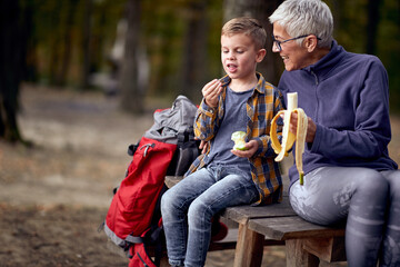 Grandmother and grandson enjoying the fruits in the forest