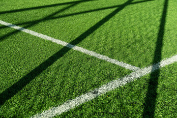 green artificial grass football or soccer field with white line and goal net shadow background - obrazy, fototapety, plakaty
