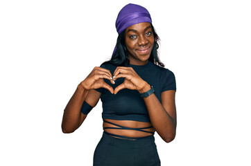 Young african american woman wearing sportswear smiling in love showing heart symbol and shape with hands. romantic concept.