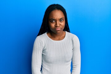 Fototapeta premium African american woman with braided hair wearing casual white sweater skeptic and nervous, frowning upset because of problem. negative person.