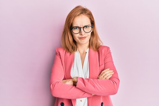 Young caucasian woman wearing business style and glasses skeptic and nervous, disapproving expression on face with crossed arms. negative person.