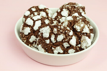 heap of chewy chocolate crinkle cookies with confectioners sugar